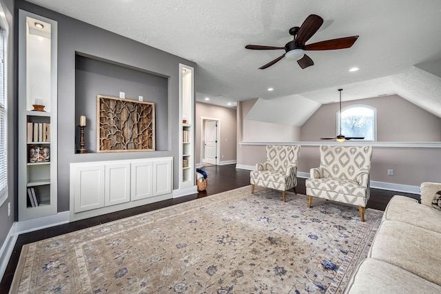 living room with vaulted ceiling, dark hardwood / wood-style floors, built in features, and a textured ceiling