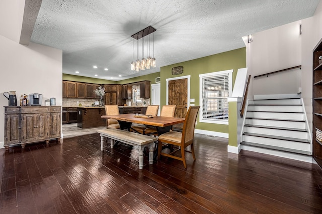 dining area with dark hardwood / wood-style flooring and a textured ceiling