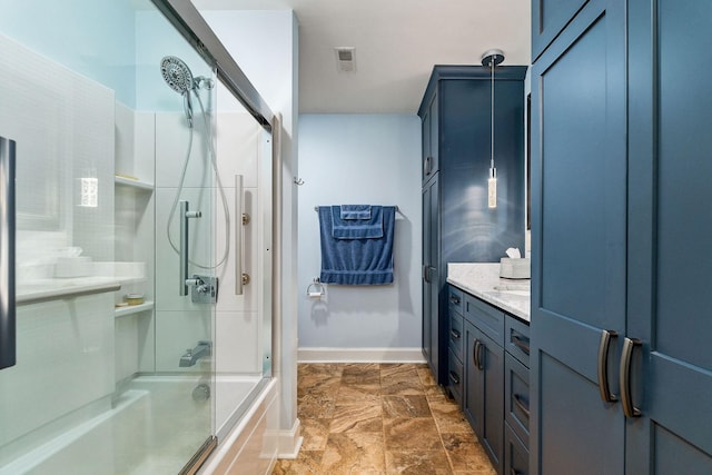 bathroom featuring vanity and shower / bath combination with glass door