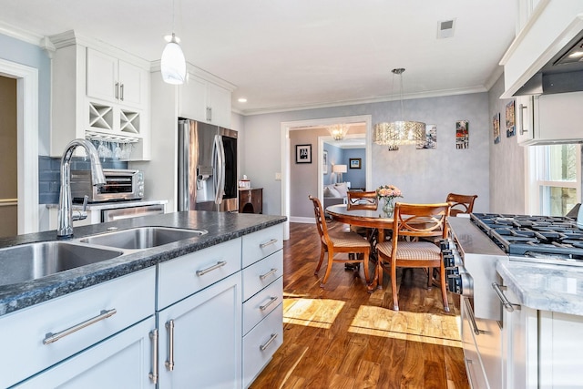 kitchen with decorative light fixtures, sink, white cabinets, stainless steel appliances, and dark wood-type flooring