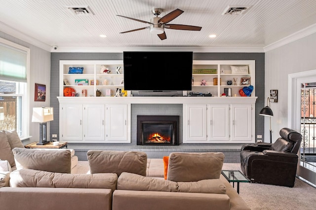 carpeted living room with crown molding, ceiling fan, and a fireplace