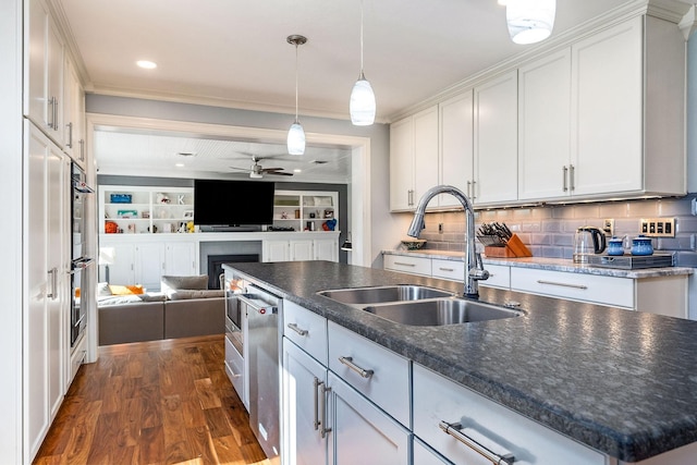 kitchen with pendant lighting, sink, white cabinetry, a center island with sink, and dark hardwood / wood-style flooring