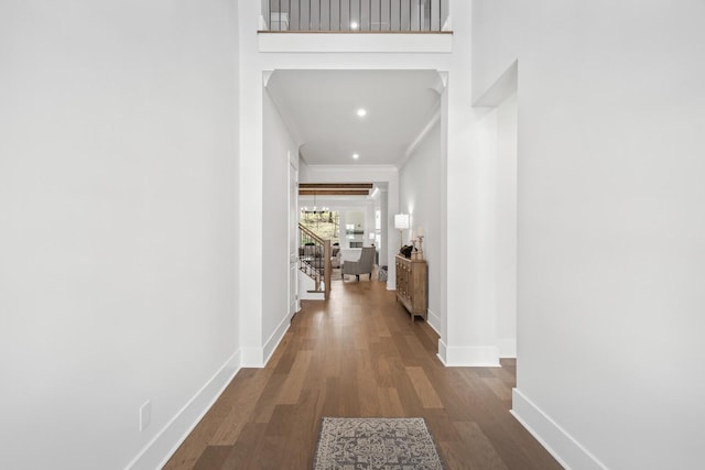 corridor featuring an inviting chandelier, crown molding, and wood-type flooring