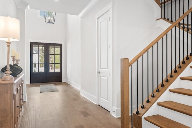 entryway featuring french doors, an inviting chandelier, and light hardwood / wood-style floors