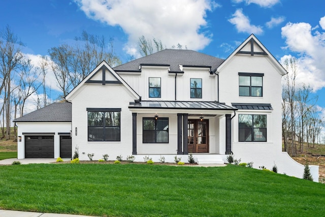 modern farmhouse featuring a garage, a front lawn, and french doors