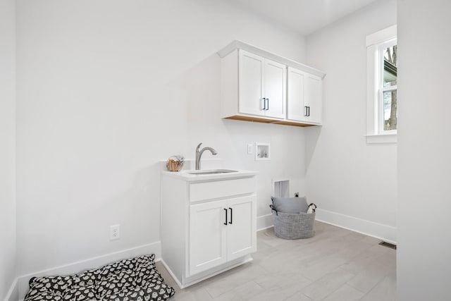 laundry room with sink, cabinets, hookup for a gas dryer, hookup for a washing machine, and electric dryer hookup