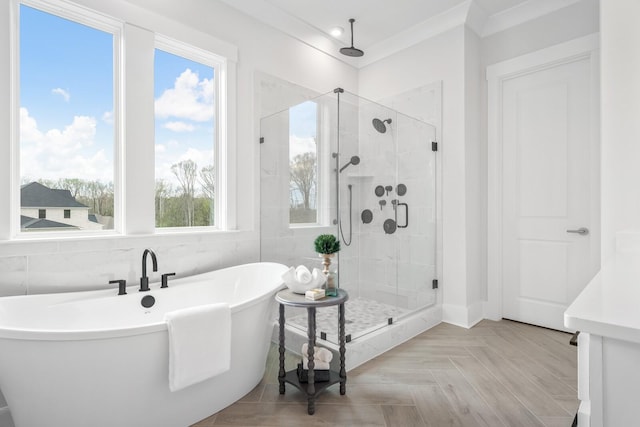 bathroom with plus walk in shower, plenty of natural light, parquet floors, and crown molding