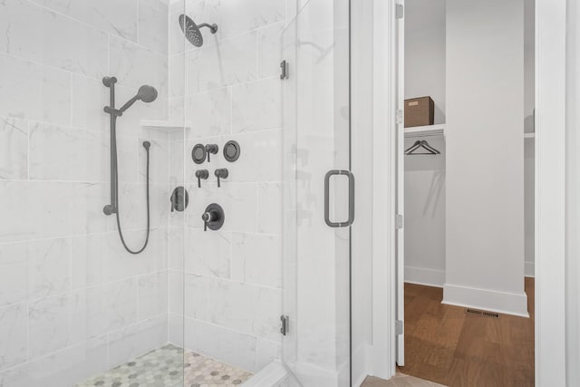 bathroom featuring wood-type flooring and walk in shower