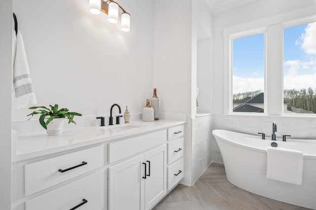 bathroom with a washtub, vanity, and tile walls