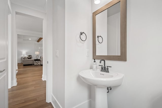 bathroom featuring hardwood / wood-style flooring and beamed ceiling