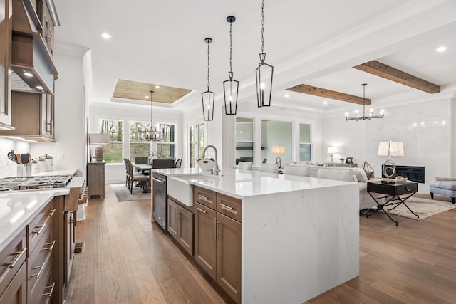 kitchen with a notable chandelier, decorative light fixtures, exhaust hood, and a spacious island