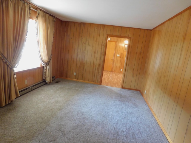 unfurnished room featuring carpet floors, wooden walls, and baseboard heating