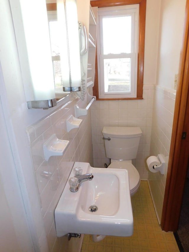 bathroom featuring tile walls, sink, and toilet