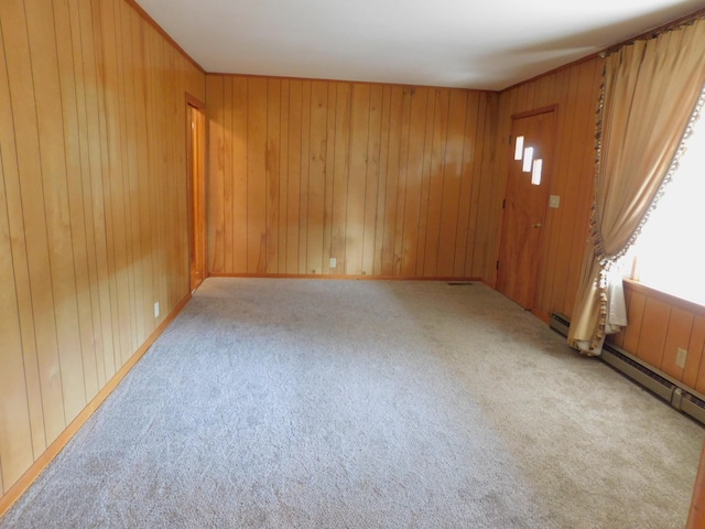 unfurnished room featuring wooden walls and light colored carpet