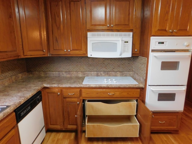 kitchen featuring white appliances and light hardwood / wood-style flooring