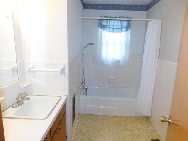 bathroom featuring tile walls, vanity, and shower / bath combination with curtain