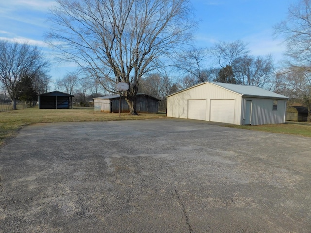 view of yard featuring a carport, a garage, and an outdoor structure