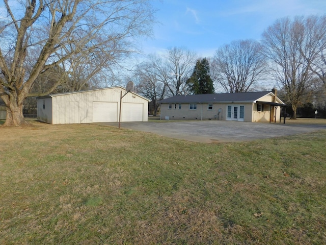 view of yard featuring french doors, a garage, and an outdoor structure