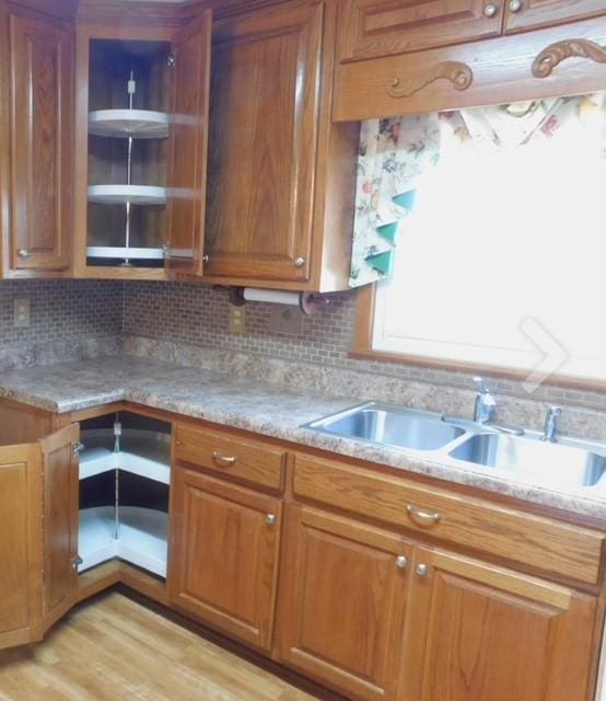 kitchen featuring tasteful backsplash, light hardwood / wood-style floors, and sink