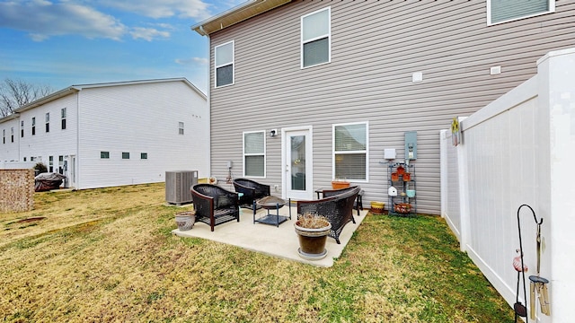 rear view of house with a yard, central AC unit, and a patio area