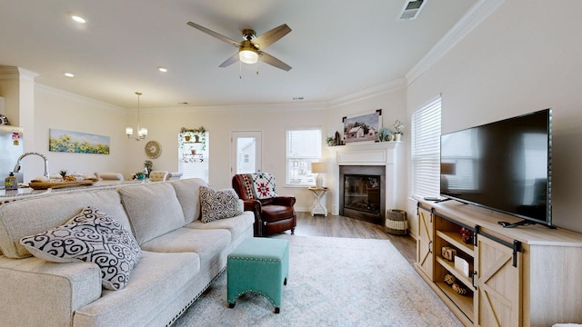 living room featuring crown molding, ceiling fan, and light hardwood / wood-style floors