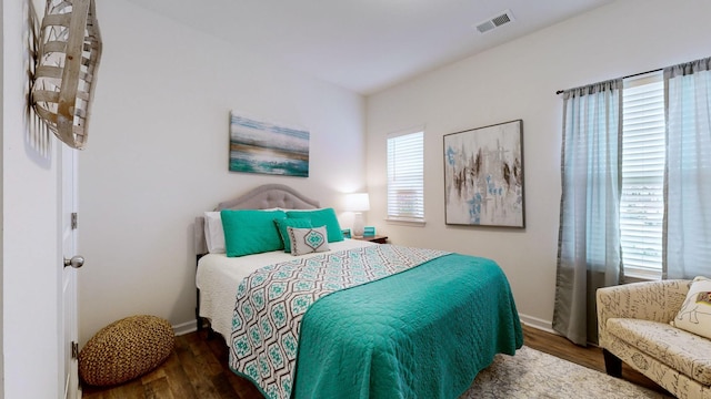 bedroom with dark hardwood / wood-style flooring