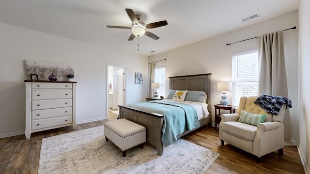 bedroom featuring ceiling fan, ensuite bathroom, and dark hardwood / wood-style floors