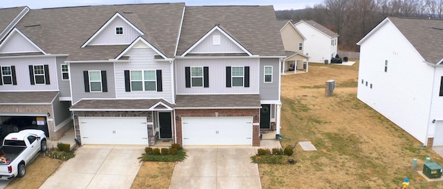 townhome / multi-family property featuring a garage and a front yard