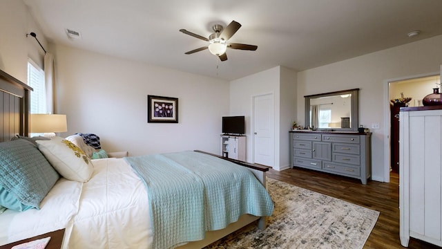 bedroom with dark hardwood / wood-style flooring and ceiling fan