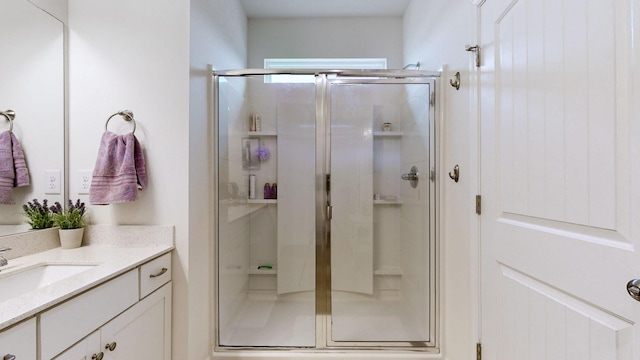 bathroom with vanity and a shower with door