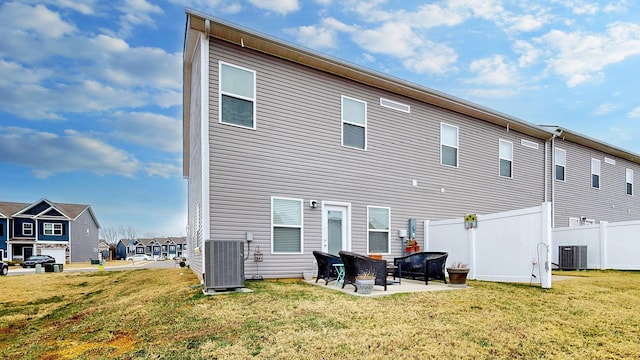 back of property with central AC unit, a lawn, and a patio