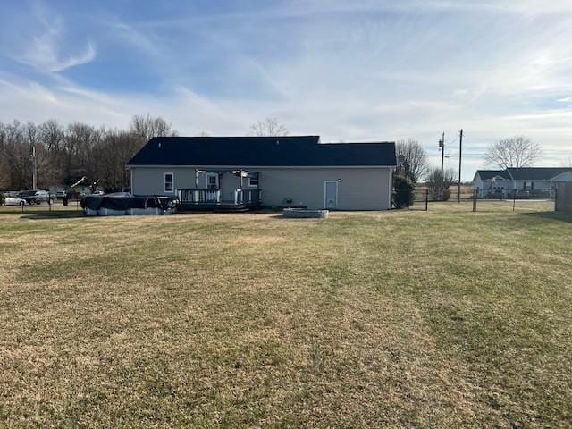 back of house with a wooden deck and a lawn