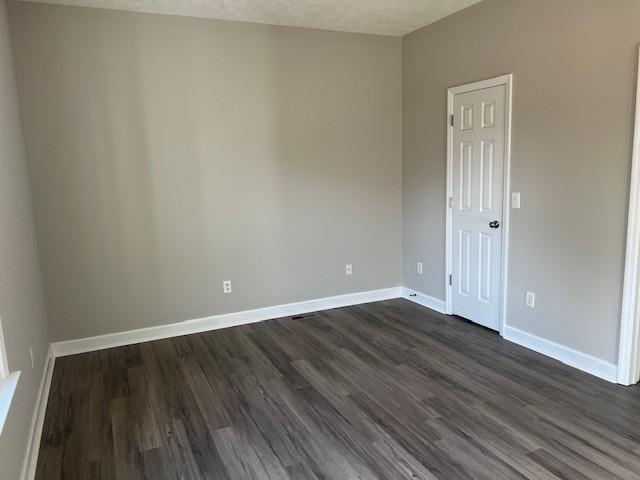 unfurnished room featuring dark hardwood / wood-style floors