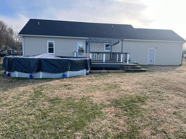 rear view of property featuring a swimming pool side deck and a yard