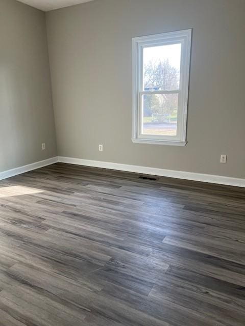 spare room with dark wood-type flooring