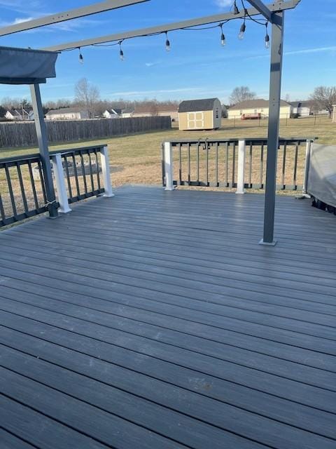 deck featuring a yard and a storage unit