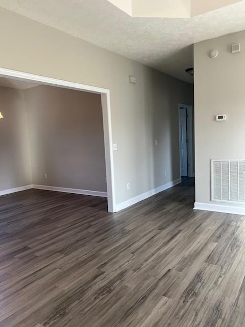 unfurnished room with dark hardwood / wood-style floors and a textured ceiling