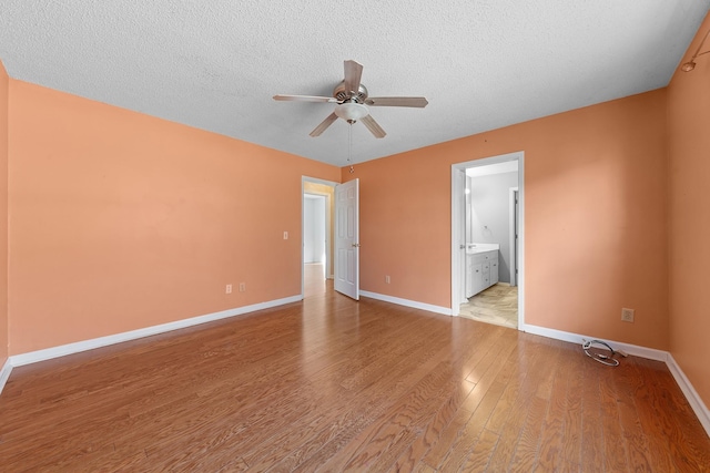 unfurnished bedroom with connected bathroom, a textured ceiling, light hardwood / wood-style floors, and ceiling fan