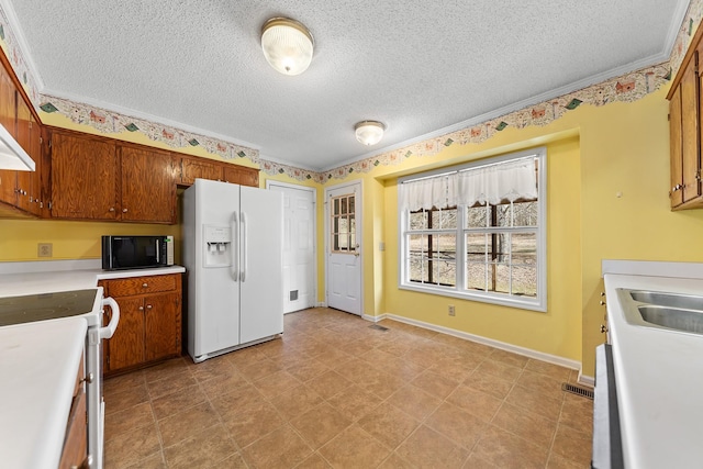 kitchen with crown molding, white appliances, sink, and a textured ceiling