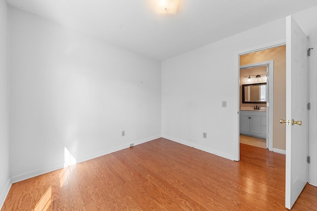 unfurnished room with sink and light hardwood / wood-style flooring