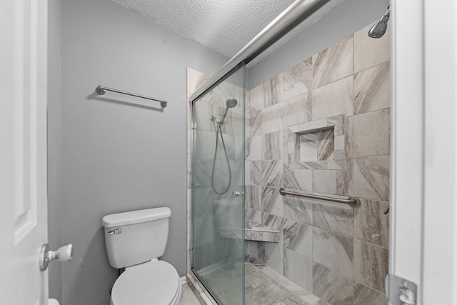 bathroom with an enclosed shower, toilet, and a textured ceiling