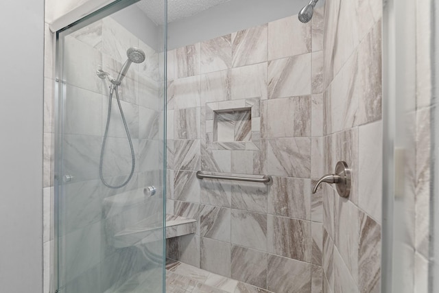 bathroom with an enclosed shower and a textured ceiling