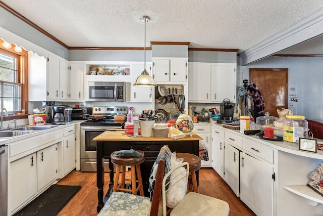 kitchen featuring sink, white cabinetry, light hardwood / wood-style flooring, pendant lighting, and stainless steel appliances