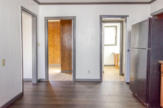 corridor with crown molding, dark hardwood / wood-style floors, and wood walls