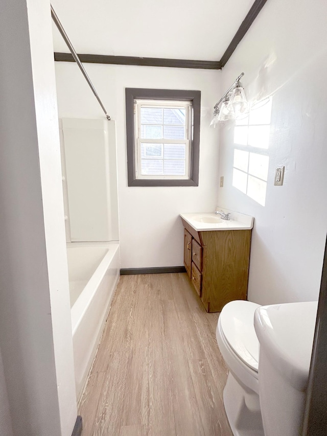 full bathroom with toilet, bathing tub / shower combination, crown molding, wood-type flooring, and vanity