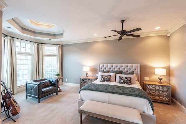 bedroom with a raised ceiling, crown molding, light colored carpet, and ceiling fan