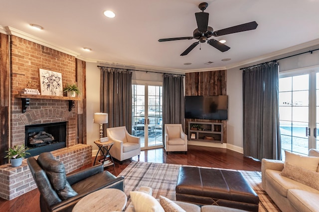 living room with a brick fireplace, ornamental molding, dark hardwood / wood-style floors, and ceiling fan