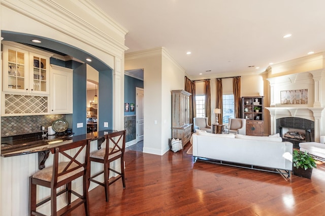 living room with dark wood-type flooring and ornamental molding