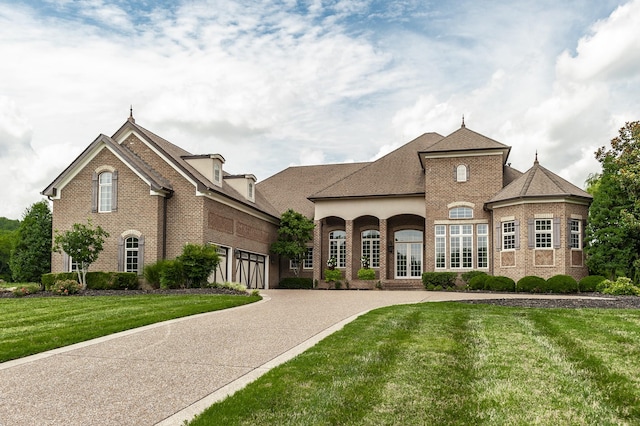 french country style house with a garage and a front lawn