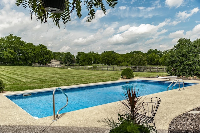 view of swimming pool featuring a yard and a rural view